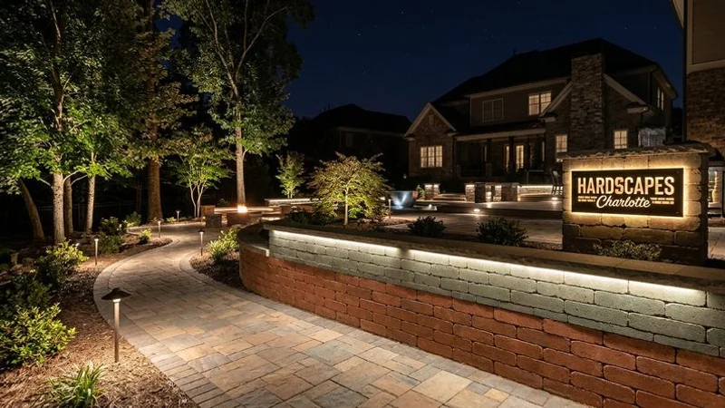 Professional landscape lighting illuminating a Charlotte home exterior, walkway, and outdoor living areas creating dramatic nighttime curb appeal